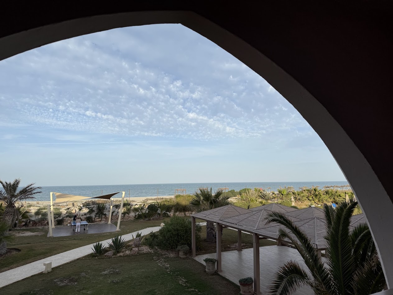 Djerba — arched window framing the beach and sea