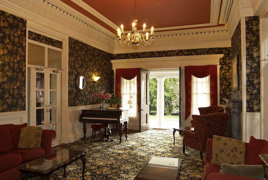 Overwater Hall interior — drawing room with piano and open fire